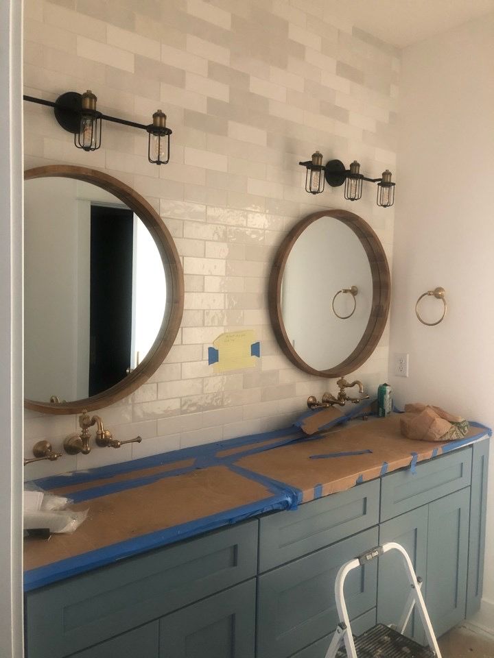 Cage vanity lights over round bathroom mirrors