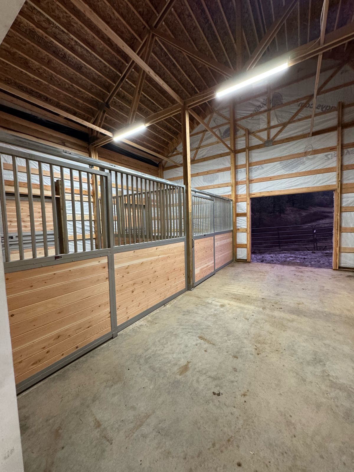 Horse barn with stalls lit by LED fixtures
