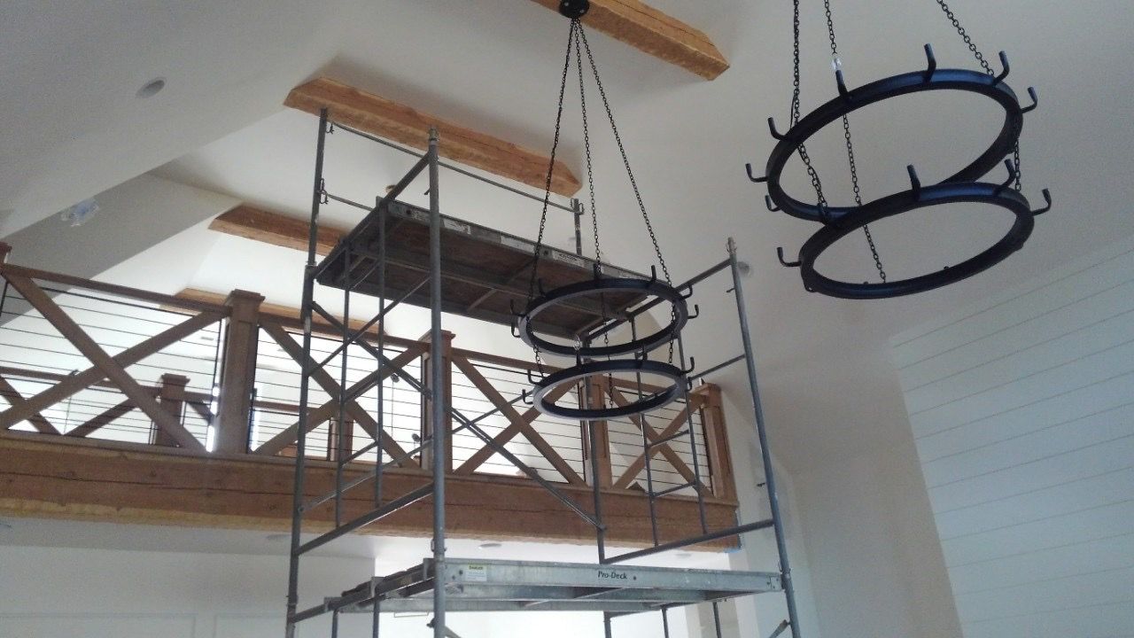 Iron ring chandeliers in a great room during construction