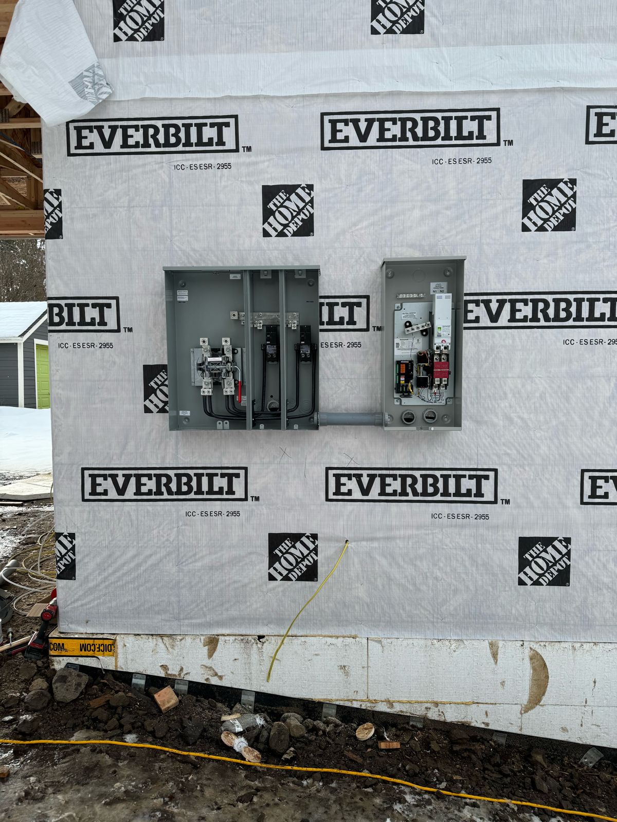 New-construction meter base and transfer switch mounted on house wrap