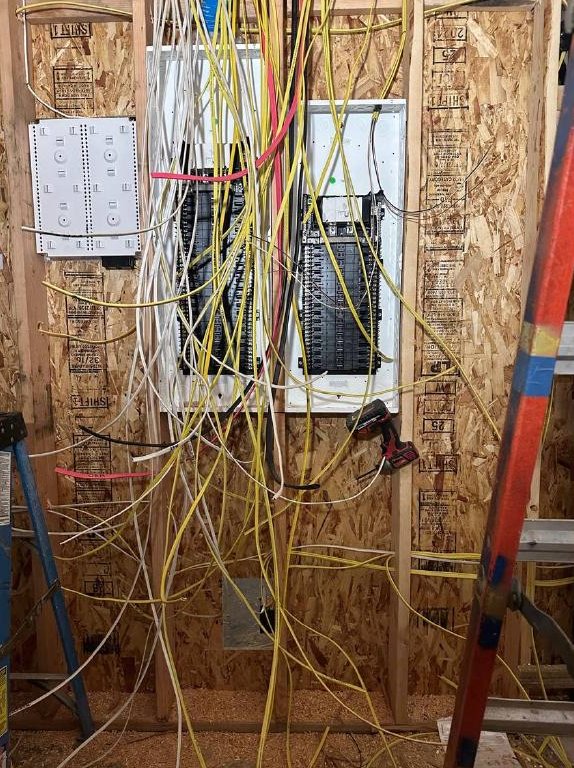 Electrical panels and wiring rough-in on a framed wall