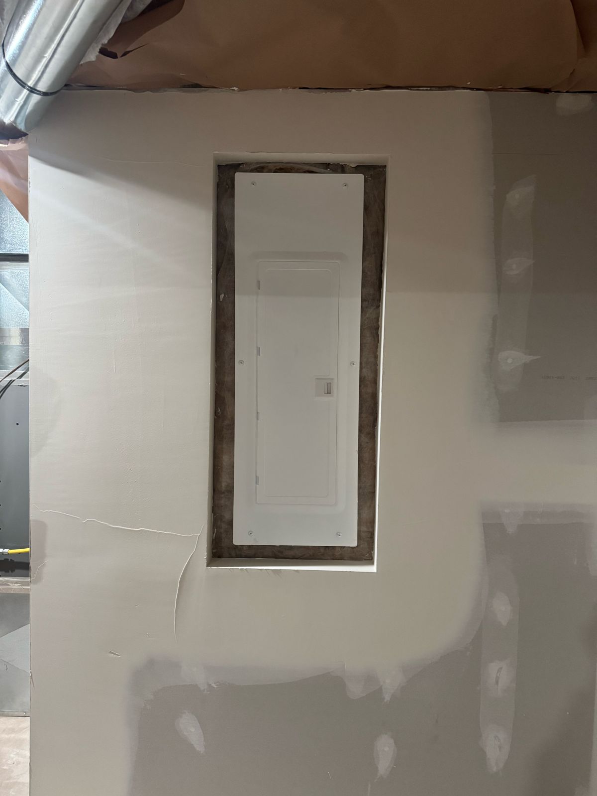 New electrical panel recessed flush into an interior drywall wall